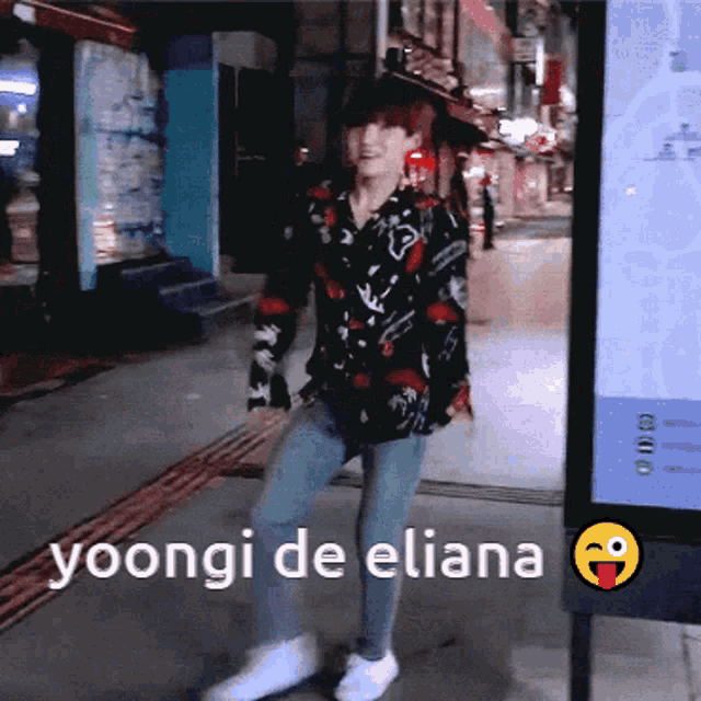 a young man is dancing in front of a sign that says yoongi de eliana on it