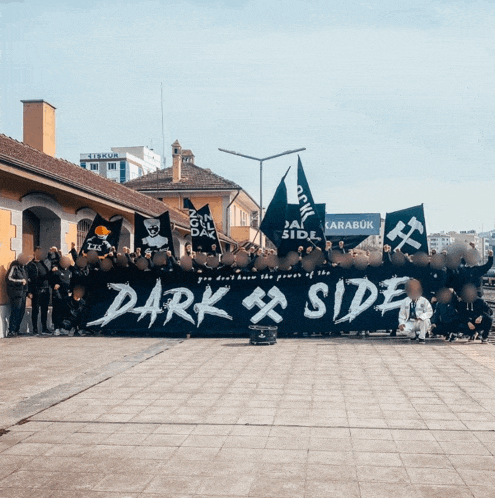 a large group of people holding a banner that says dark side