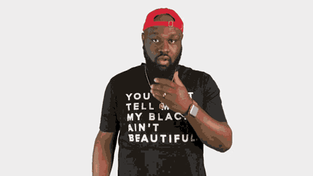 a man wearing a black t-shirt that says you can tell me my black ain 't beautiful