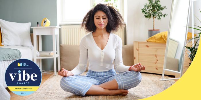 Person sitting cross legged on the floor with hands on knees and palms up