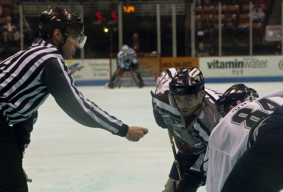 hockey judge with a puck on ice