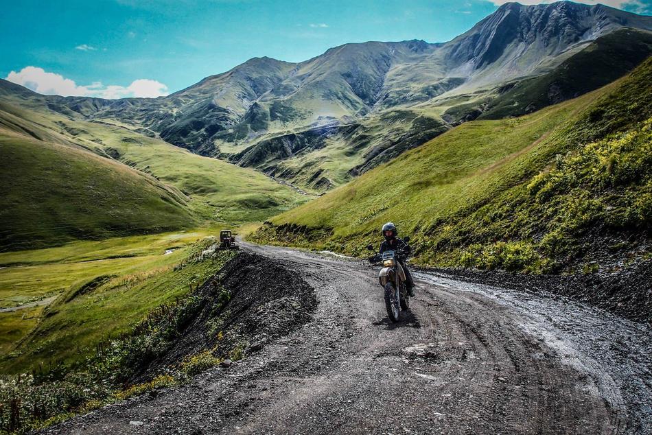 man riding Motorcycle on Mountain Road in scenic Landscape