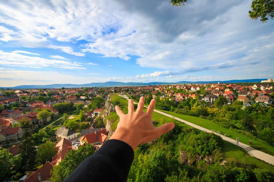 male hand stretched to suburban summer landscape