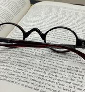 black round eyeglasses on open Book