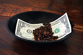 roasted coffee beans on one Dollar bill