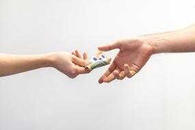 female hand passing money to male Hand