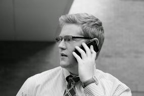 young caucasian man in glasses with phone at ear