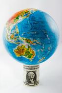 dollar bill under the globe