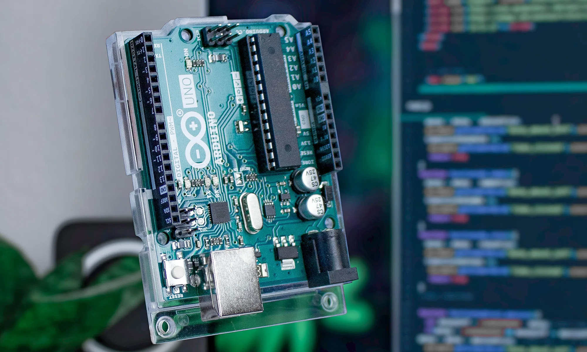 An arduino uno microcontroller board with its sketch code on Arduino IDE being used as background in a monitor.