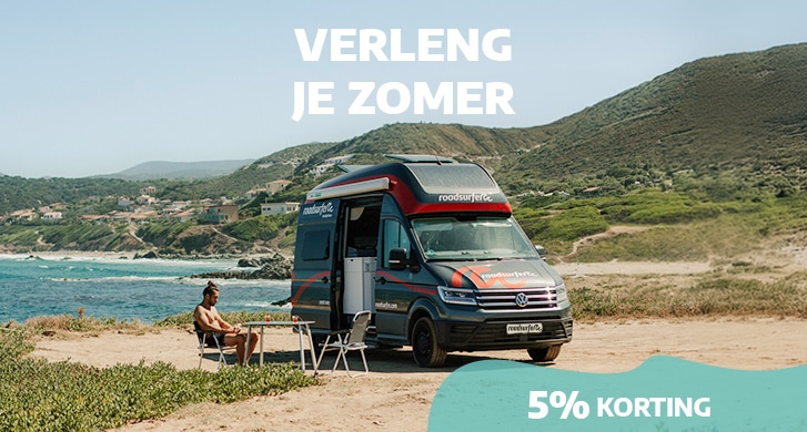 Late summer roadsurfer promotion with man sitting at a table next to the beach and a sprinter campervan enjoying the late summer sun