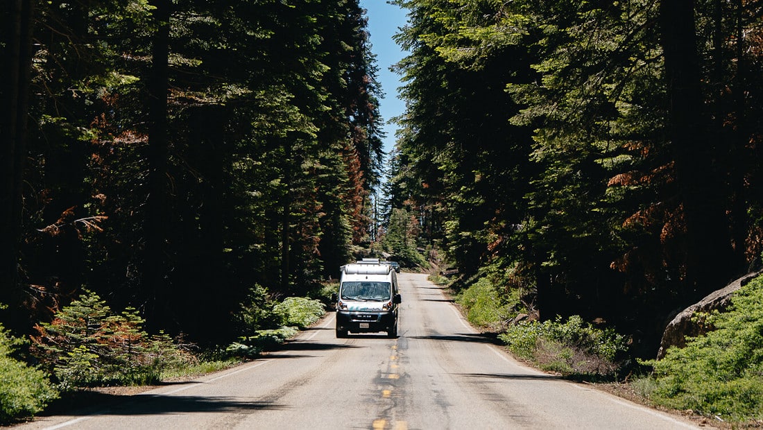 motorhome driving on a road through a forest