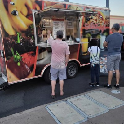 Photo of River Park Farmers Market - Fresno, CA, US. people ordering food from a food truck