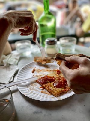 Photo of Grand Street Pizza - New York, NY, US. a person eating a slice of pizza