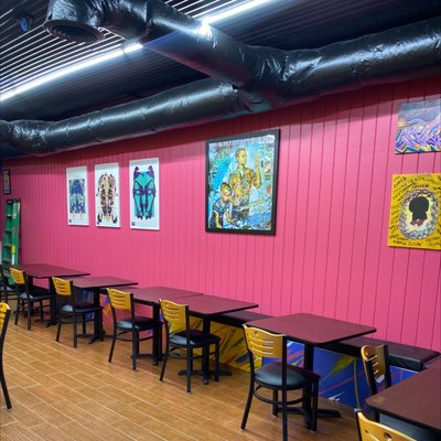 Photo of Chez Quan’s - Satellite Beach, FL, US. tables and chairs in a brightly colored room