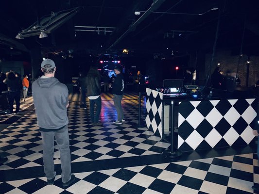 Photo of Black Cat - Washington, DC, DC, US. a man standing in front of a black and white checkered floor