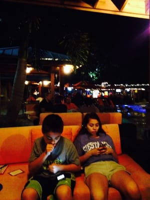 Photo of Osprey Beach Tiki Bar and Grille - Osprey, FL, US. two people sitting on a couch