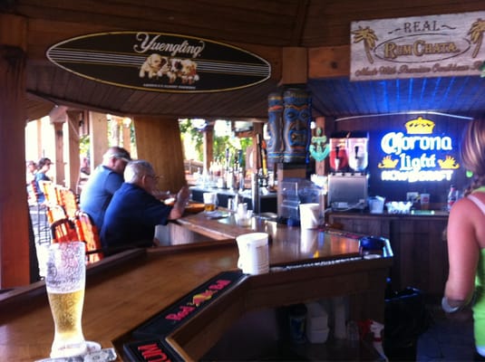 Photo of Osprey Beach Tiki Bar and Grille - Osprey, FL, US. people sitting at the bar