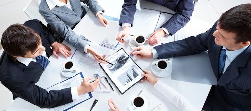 Above view of business team discussing papers at meeting