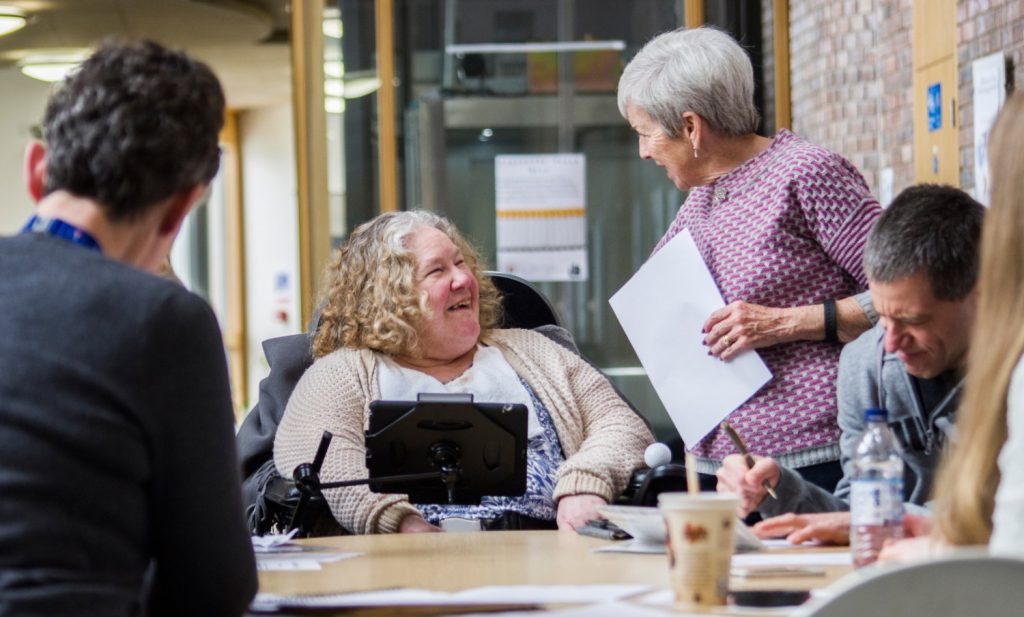 A person using AAC in conversation with a volunteer