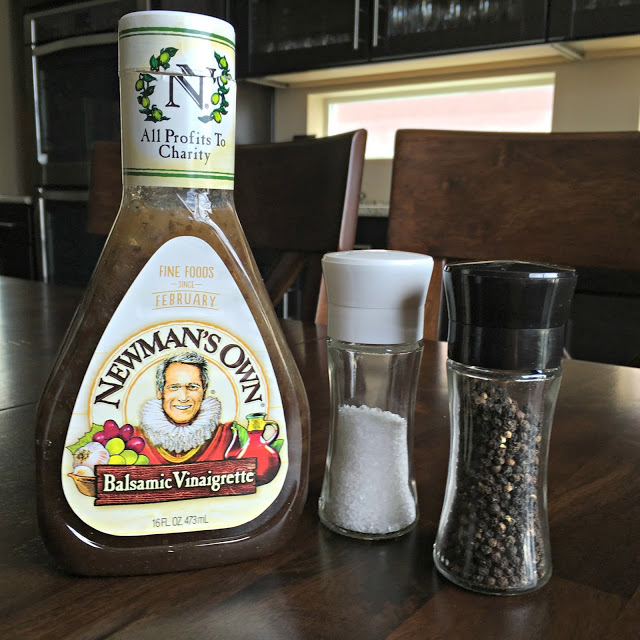 This photo shows a bottle of Newman's Own Balsamic Vinaigrette and salt and pepper shakers. 