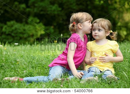 Two little girls telling secrets, outdoor