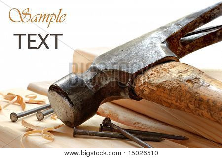 Vintage hammer with nails and wood on white background with copy space.  Macro with shallow dof.