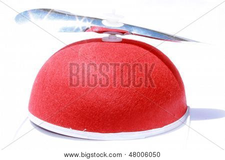 A Genuine Red Felt Beanie Cap with a Silver Mylar Propeller attached, isolated on white. A very hard to find hat or head wear direct from the far reaches of the earth for you to use.