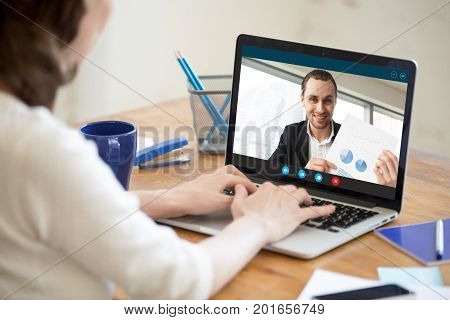 Businesswoman talking on video conference to businessman showing document at webcam, colleagues discussing work by video call application, financial consultant consulting client online, close up view