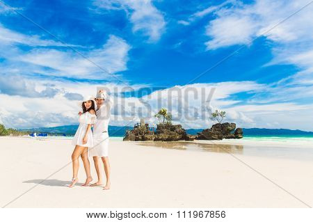 Happy Bride and Groom having fun on the tropical beach. Wedding and honeymoon concept.