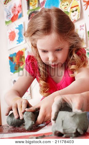  Child girl mould from clay in play room. Preschool.