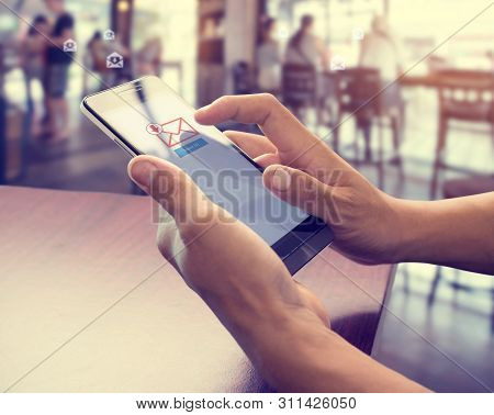 Hand Of Male Using Mobile Phone To Open New E-mail Message Inbox With Email Symbol And Envelope Icon