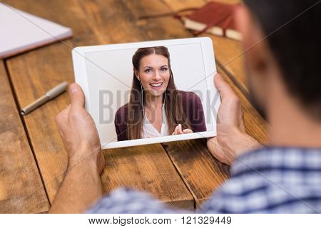 Closeup of a woman talking through video chat on tablet. Young man communicating with his girlfriend on tablet in video chat. Man looking at screen of tablet and talking with a girl through webcam.