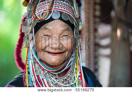 CHIANG RAI, THAILAND - DEC 4: Unidentified Akha tribe elderly woman with traditional clothes and silver jewelery in hill tribe minority village on December 4, 2013. Mae Hong Son, Thailand. 