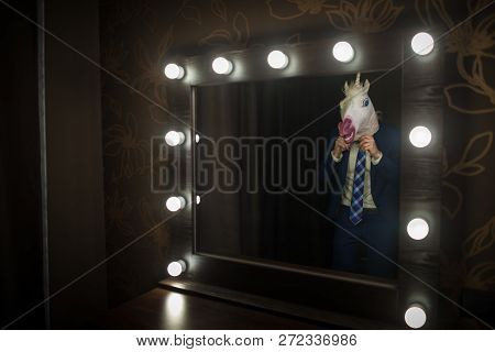 Glamour Guy In Elegant Suit Wearing Mask And Looks At Himself In Mirror In Dressing Room. Freaky You