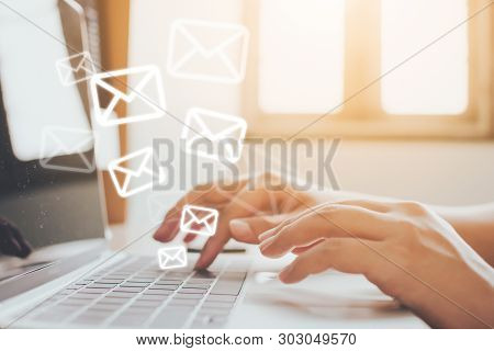 Email Marketing And Newsletter Concept. Hand Of Man Sending Message And Laptop With E-mail Icon