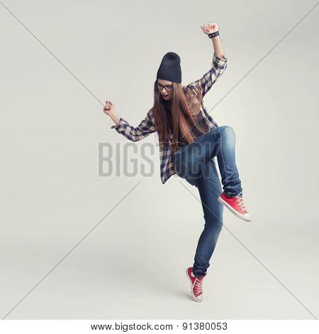 Dancing hipster girl in glasses and black beanie