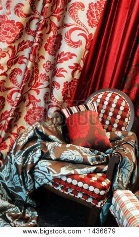 Luxurious Red Chair With Satin Pillows And Curtains