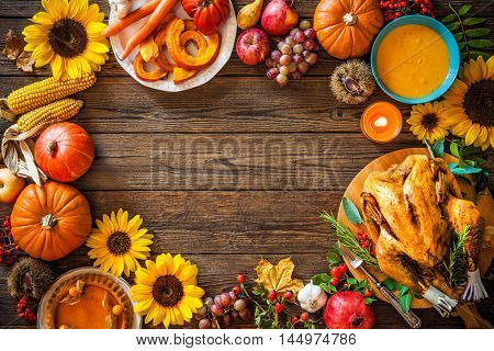 Thanksgiving dinner. Roasted turkey with pumpkins and sunflowers on wooden table