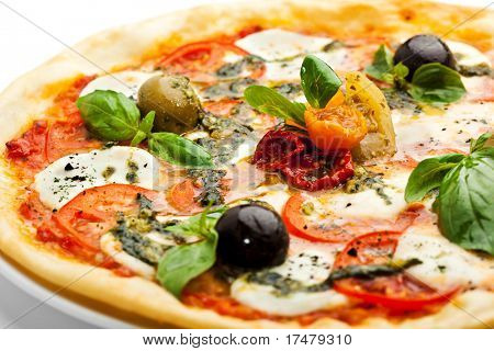 Pizza z serem Mozzarella i świeżych pomidorów oraz sosem Pesto. Przyozdobionym z suszonych pomidorów, zielony