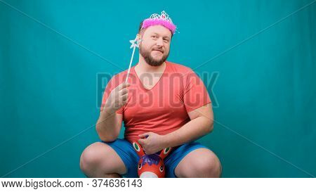 A Youna Young Bearded Freaky Man In A Pink T-shirt With A Diadem On His Head Riding A Unicorn With A