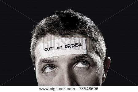 Young Man With Blue Eyes And Tape Text Out Of Order On Forehead In Dry Empty Mind