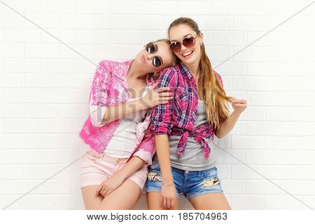 Fashion portrait of two friends posing. modern lifestyle. two stylish sexy hipster girls best friends ready for party. Two young girl friends standing together and having fun.