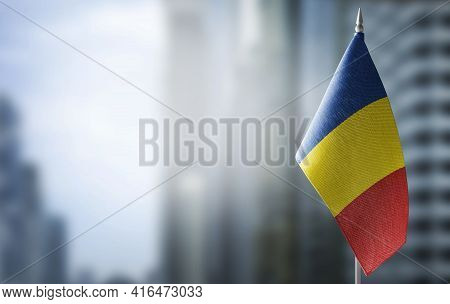 A Small Flag Of Romania On The Background Of A Blurred Background