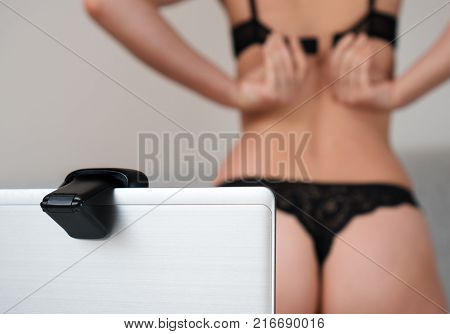 Woman working as webcam model. Removes the bra.