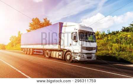 Big White Truck On The Road In A Rural Landscape At Sunlight. Perfect Sky. Over The Aspfalt Road At 