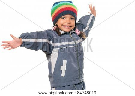 Happy mixed race little girl wearing a colorful beanie hat offering a hug with wide open arms isolated on white