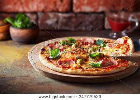 Thin crust pizza with ham, cheese and olive.  Freshly baked pizza (from wood-fired oven).