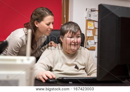 Caregiver And Mentally Disabled Woman Learning At The Computer