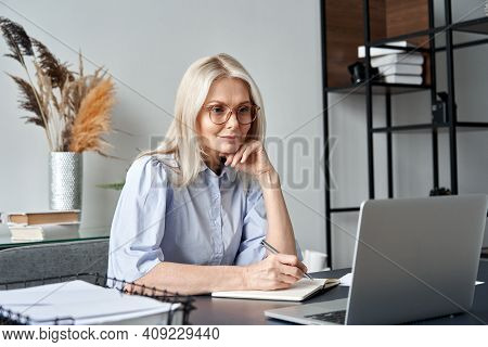 Middle Aged Older Business Woman Watching Professional Training Class, Online Webinar On Laptop Comp