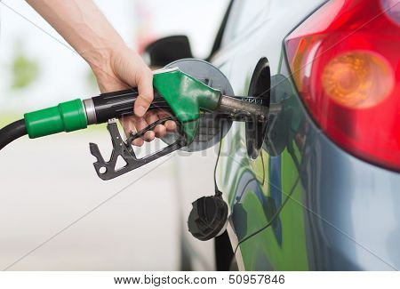 transportation and ownership concept - man pumping gasoline fuel in car at gas station